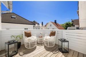 a patio with chairs and tables on a balcony at Large & Cozy Stavanger Apt in Stavanger
