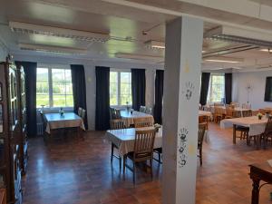 a dining room with tables and chairs and windows at Porsangerfjorden Lodge in Børselv