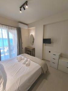 a bedroom with a white bed with towels on it at Irene Studios in Nydri