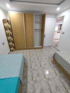 an empty room with two beds and a closet at Golden plage in Kelibia