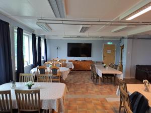 a dining room with tables and chairs and a flat screen tv at Porsangerfjorden Lodge in Børselv