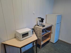 a small kitchen with a microwave and a refrigerator at Porsangerfjorden Lodge in Børselv