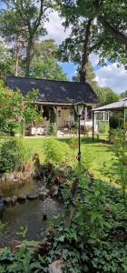 a house with a pond in front of it at Ferienhaus Schatz in Siedlung Schönwalde