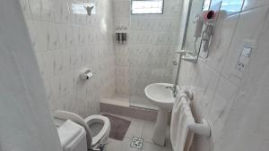 a white bathroom with a sink and a toilet at Colores Rio Cuarto in Río Cuarto