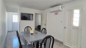 a dining room table with chairs and a television on the wall at Colores Rio Cuarto in Río Cuarto