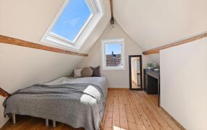 a attic bedroom with a bed and a window at Large & Cozy Stavanger Apt in Stavanger