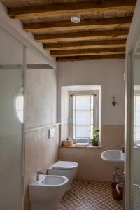 a bathroom with two sinks and a toilet and a window at Agriturismo Poderino in Cinigiano +95 photos