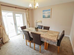 a dining room with a wooden table and chairs at Sandringham in Withernsea