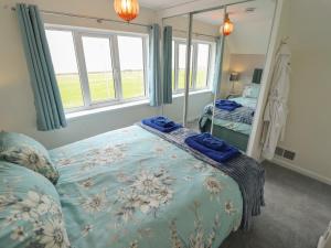 a bedroom with a bed with a blue blanket at Sandringham in Withernsea