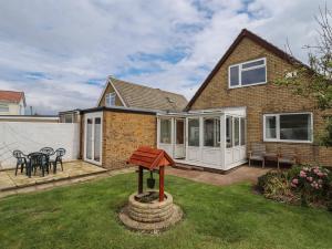 a house with a garden with a wooden sign in the yard at Sandringham in Withernsea