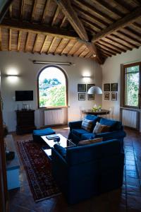 a living room with blue couches and a large window at Villa Santa Chiara in Siena