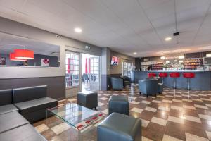 a lobby with a couch and chairs and a bar at TheOriginals City, Hôtel restaurant l'Ormichal Dijon Sud in Marsannay-la-Côte