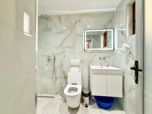 a white bathroom with a toilet and a sink at Villa Reshat Caca in Ksamil +54 photos