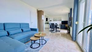 a living room with a blue couch and a table at Marevista in Dramalj