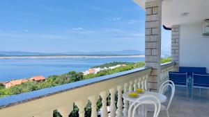 a balcony with a table and chairs and a view of the water at Marevista in Dramalj