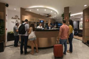 a group of people waiting at the counter of a restaurant at Real Hotel in Juiz de Fora