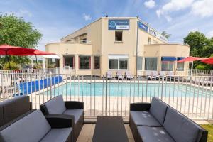 a pool with chairs and umbrellas in front of a building at TheOriginals City, Hôtel restaurant l'Ormichal Dijon Sud in Marsannay-la-Côte