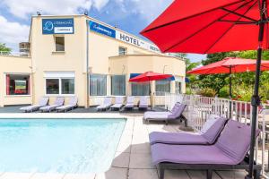 a pool with chairs and umbrellas next to a hotel at TheOriginals City, Hôtel restaurant l'Ormichal Dijon Sud in Marsannay-la-Côte