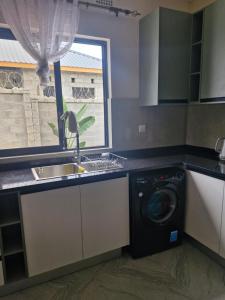 a kitchen with a washing machine and a sink at Cosy Corner Villa in Lusaka