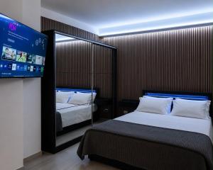 a hotel room with two beds and a flat screen tv at Seven Suite SPA in Fiumicino