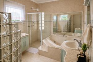 a bathroom with a tub and a shower and a sink at Pousada Casa Contos de Minas in Ubatuba +40 photos