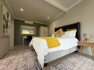 a bedroom with a large bed and a rug at McCrae's Garden Suite in Malmesbury