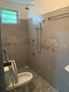 a bathroom with a shower and a toilet and a sink at At 35 Resort in Anuradhapura
