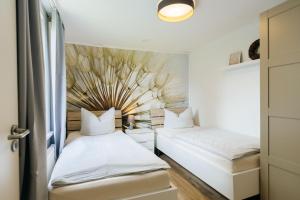 two beds in a room with a wall at Hof Timmermann - Landhaus, oben in Ottenstein