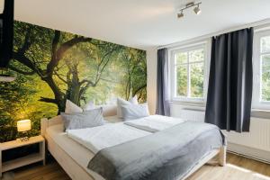 a bedroom with a large tree mural on the wall at Hof Timmermann - Landhaus, oben in Ottenstein