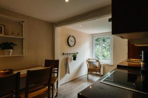 a kitchen with a table and a clock on the wall at Hof Timmermann - Landhaus, oben in Ottenstein +5 photos