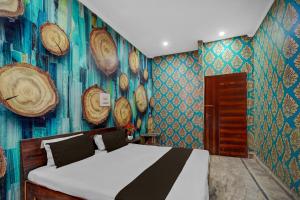 a bedroom with a bed in a room with blue walls at Hotel O Refinery Road Panipat Formerly Quinn in Pānīpat