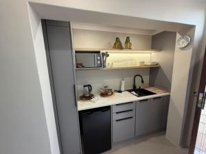 a small kitchen with a sink and a microwave at McCrae's Garden Suite in Malmesbury