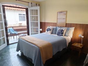 a bedroom with a bed and a view of a balcony at Casa da Prainha - a 3min da areia - aproveite até o pôr do sol! in Arraial do Cabo