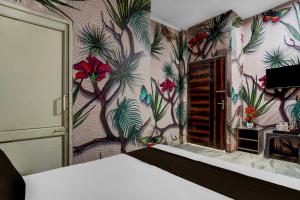 a bedroom with a wall with a floral wallpaper at Hotel O Refinery Road Panipat Formerly Quinn in Pānīpat +21 photos
