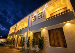 a building with potted plants in front of it at night at Araliya Hotel in Badulla