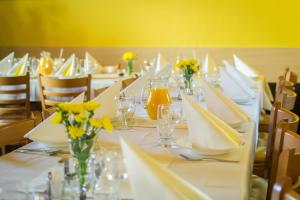 Zlechov的住宿－Penzion V Koutě，一张长桌子,上面有白色的桌子和黄色的花