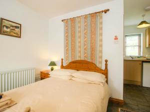 a bedroom with a bed with white sheets at Apartment 2 in North Lydbury