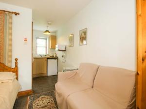 a living room with a couch and a kitchen at Apartment 2 in North Lydbury