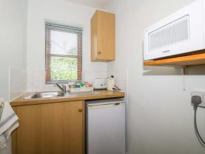 a small kitchen with a sink and a refrigerator at Apartment 2 in North Lydbury
