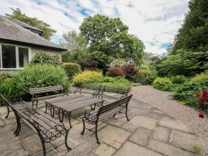 a picnic table and benches in a garden at Apartment 2 in North Lydbury