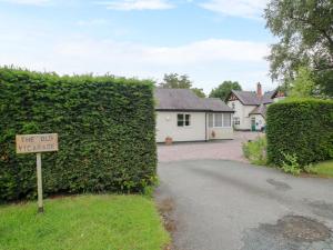a house with a sign in front of a hedge at Apartment 2 in North Lydbury +17 photos