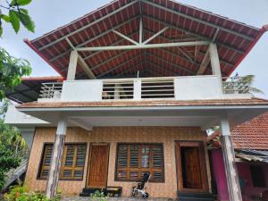 a building with a balcony on top of it at Shrunga Shreni Homestay - Near Bandaje trek and falls in Kalasa