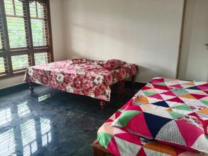 a room with two beds in a room at Shrunga Shreni Homestay - Near Bandaje trek and falls in Kalasa