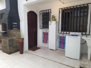 a room with two refrigerators and a door in a house at Casa da Prainha - a 3min da areia - aproveite até o pôr do sol! in Arraial do Cabo