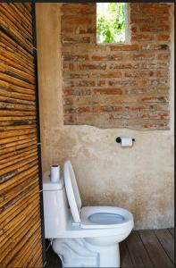 a bathroom with a toilet and a brick wall at Domo Abitare Glamping in Isla de Mezcala