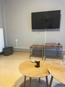 a living room with two tables and a flat screen tv at Nia The Yard in Nafpaktos +22 photos