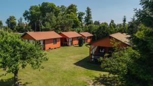 a group of cottages in a field with trees at Bryza Jantar apartamenty z sauną & domki z kominkami in Jantar