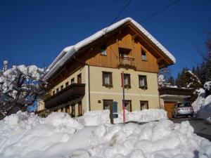 ein Gebäude mit einem Schneehaufen davor in der Unterkunft Haus Jost Ingrid in Hermagor