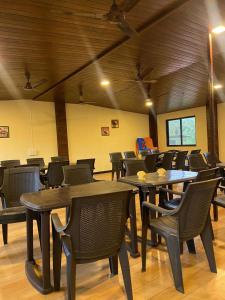 a room with tables and chairs in a building at Shree Krishna Sudha Resort in Alibaug