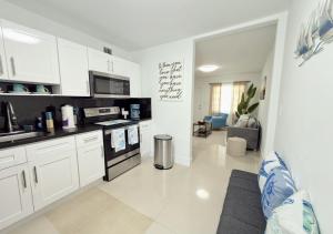 a kitchen with white cabinets and a stove top oven at Miami Blue Oasis l 2BR with free parking in Miami